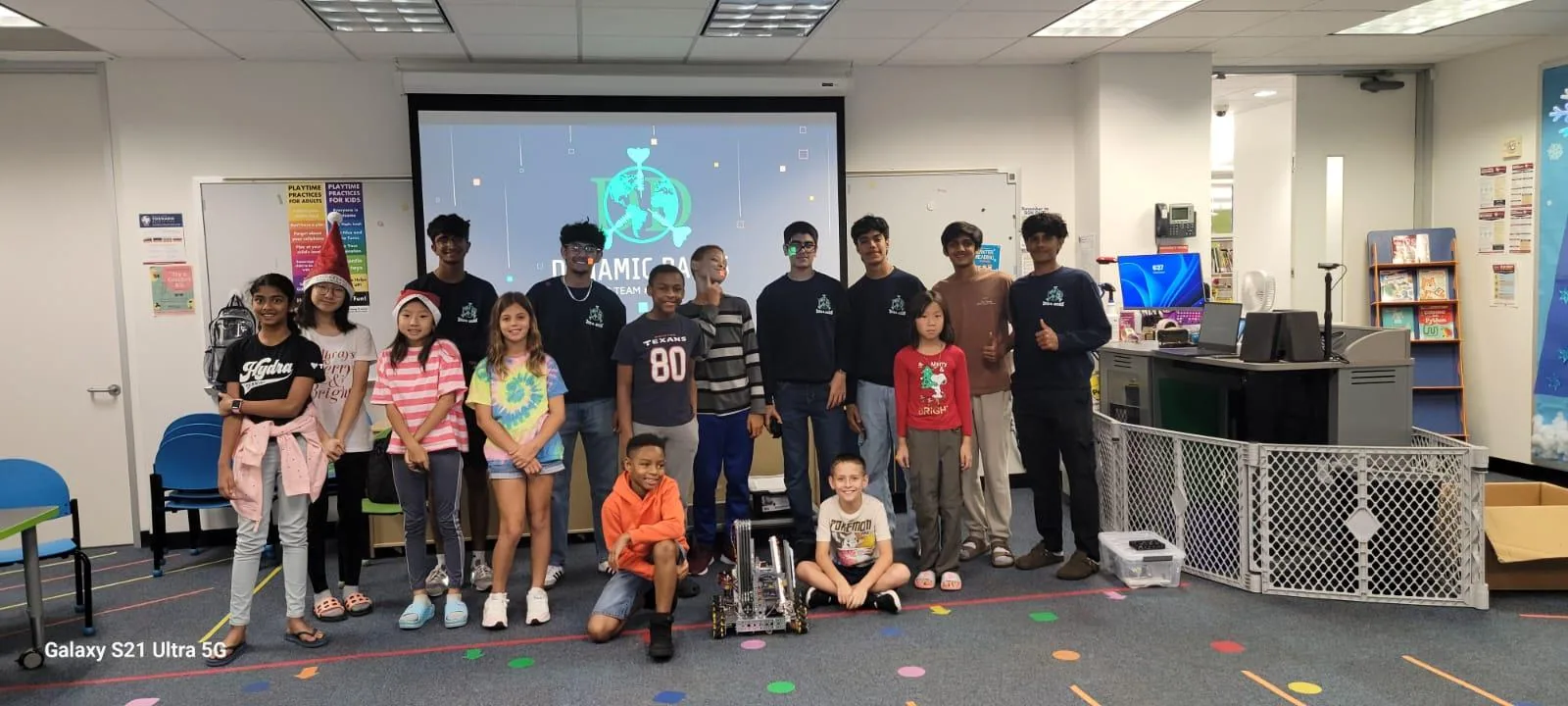 Team members and students at a youth robotics workshop